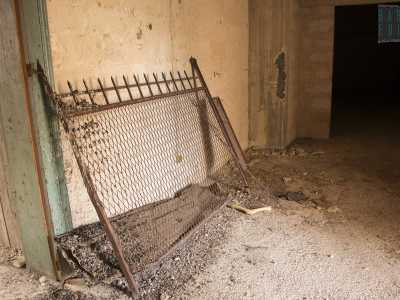 Appoggiato a un muro c'� un pezzo di ringhiera circondato dalla polvere...